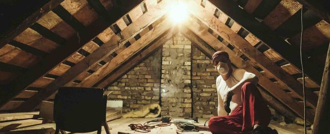 A photo of a man cleaning an attic.